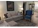 Cozy living room featuring a plush sofa, blue armchair, area rug, and stylish decor at 459 S Boojum Way, Mesa, AZ 85208