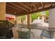 Covered patio featuring outdoor dining set, grill, and charming desert landscape in this lovely home at 459 S Boojum Way, Mesa, AZ 85208