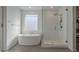 Modern bathroom featuring a soaking tub, a glass-enclosed shower, and a large window at 4878 W Elijah Ln, San Tan Valley, AZ 85144