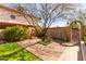 Serene backyard oasis with mature landscaping, a charming fireplace, and a decorative gate at 4946 W Evans Dr, Glendale, AZ 85306