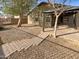 Landscaped backyard with a stone pathway, covered patio and desert plants, perfect for outdoor activities at 517 S 125Th Ave, Avondale, AZ 85323