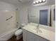 Bright bathroom featuring a shower-tub combo, white vanity, large mirror and ample lighting at 517 S 125Th Ave, Avondale, AZ 85323