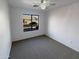 Sunlit bedroom featuring a ceiling fan, carpet, white walls, and a large window with neighborhood views at 517 S 125Th Ave, Avondale, AZ 85323