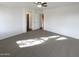 Spacious bedroom with carpet, a ceiling fan, and two entryways at 517 S 125Th Ave, Avondale, AZ 85323