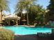 Resort-style pool area with swaying palm trees, comfortable lounge chairs, and a relaxing gazebo at 5335 E Shea Blvd # 1095, Scottsdale, AZ 85254