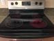 A black glass cooktop stove with four burners, two of which are radiant red at 5335 E Shea Blvd # 1095, Scottsdale, AZ 85254