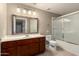 Bathroom with wood vanity, tub-shower combo, and large framed mirror over the sink at 5345 E Van Buren St # 167, Phoenix, AZ 85008