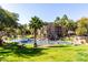 Beautiful community pond with a waterfall, palm trees, and well-manicured lawn at 5345 E Van Buren St # 167, Phoenix, AZ 85008