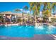 Community pool featuring fountains, lounge area, palm trees, and surrounding buildings at 5345 E Van Buren St # 167, Phoenix, AZ 85008