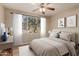 Staged main bedroom with a ceiling fan, a large window with lots of natural light at 5345 E Van Buren St # 167, Phoenix, AZ 85008