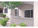 Cozy covered patio with stucco walls, green bushes, and windows at 5345 E Van Buren St # 167, Phoenix, AZ 85008