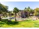 Scenic view of a community pond with palm trees, fountains, and residential buildings under a clear sky at 5345 E Van Buren St # 167, Phoenix, AZ 85008