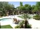 Inviting pool area with a hot tub, lounge chairs, and lush landscaping at 5345 E Van Buren St # 167, Phoenix, AZ 85008