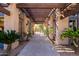 Covered walkway with decorative wood beams and lush landscaping leading to an arched gateway at 5345 E Van Buren St # 167, Phoenix, AZ 85008