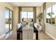 Bright dining room with a modern table, seating for six, stylish decor, and plenty of natural light from the windows at 5719 S Quartz St, Gilbert, AZ 85298