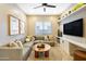 Cozy living room featuring a sectional sofa, tv, open shelving, and a round wood coffee table, perfect for relaxing at 5719 S Quartz St, Gilbert, AZ 85298