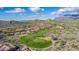 Aerial view of golf course showcasing mountain views and luxury homes surrounding lush desert at 6965 E Hacienda La Noria Ln, Gold Canyon, AZ 85118