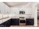 Bright kitchen with modern appliances, granite countertops, and a combination of white and navy blue cabinets at 6965 E Hacienda La Noria Ln, Gold Canyon, AZ 85118