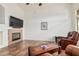 Bright living room features tile flooring, a cozy fireplace, and comfortable leather seating at 6965 E Hacienda La Noria Ln, Gold Canyon, AZ 85118