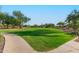 Well-manicured park with walking path, grassy area, picnic tables, and native desert vegetation at 6965 E Hacienda La Noria Ln, Gold Canyon, AZ 85118