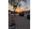 Desert landscaping accents this street view featuring a colorful sunset in the distance at 6965 E Hacienda La Noria Ln, Gold Canyon, AZ 85118