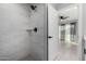 Modern bathroom with tiled shower, neutral paint, and a peek into the Primary bedroom at 700 N D St, Eloy, AZ 85131