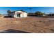 Exterior view of a home with a light-colored facade and a covered patio area at 700 N D St, Eloy, AZ 85131