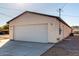 Side view of home featuring a two car garage, house number, and outdoor lighting fixtures at 700 N D St, Eloy, AZ 85131