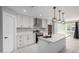 Modern kitchen with stainless steel appliances, white cabinets, a kitchen island, and open to the living space at 700 N D St, Eloy, AZ 85131