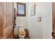 Cozy powder room with rustic wood accents and a wooden toilet seat at 9 W Glenhaven Dr, Phoenix, AZ 85045