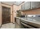 Laundry room with stainless steel washer and dryer and custom rustic cabinets at 9 W Glenhaven Dr, Phoenix, AZ 85045