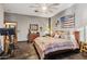 Bright main bedroom featuring a patriotic painting, wood flooring, and neutral paint colors at 9 W Glenhaven Dr, Phoenix, AZ 85045