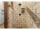 Shower featuring earth-toned tiles, wooden beams, and a pebble-lined accent at 9 W Glenhaven Dr, Phoenix, AZ 85045