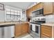 Efficient kitchen featuring stainless steel appliances, wooden cabinets, and a bright window at 921 W University Dr # 1051, Mesa, AZ 85201