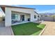A well manicured backyard including gravel and an area of artificial turf, a covered patio with furniture and an outdoor grill at 9422 S 7Th Pl, Phoenix, AZ 85042