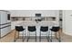 Modern kitchen featuring a large marble countertop island with seating, stainless steel appliances, and white cabinetry at 9422 S 7Th Pl, Phoenix, AZ 85042