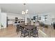 Bright open-concept living space with wood flooring, a modern dining area, and seamless flow into the white kitchen at 9422 S 7Th Pl, Phoenix, AZ 85042