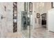 A glass shower with modern fixtures, stone walls and walk-in closet make this bathroom a unique space at 9809 W Wescott Dr, Peoria, AZ 85382