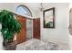 Bright foyer with tile flooring, a large decorative mirror, and views of the arched window at 9809 W Wescott Dr, Peoria, AZ 85382