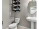 Well-lit bathroom features a pedestal sink and rustic shelving for towels and décor items at 1039 W Tuli Way, San Tan Valley, AZ 85143