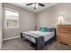 Cozy bedroom with a ceiling fan and a well-lit window, complemented by soft carpeting at 1039 W Tuli Way, San Tan Valley, AZ 85143