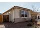 Exterior view of home with gravel landscaping, a wood fence, and shuttered windows at 1039 W Tuli Way, San Tan Valley, AZ 85143