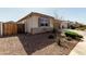 Exterior view of home with gravel landscaping, a wood fence, and shuttered windows at 1039 W Tuli Way, San Tan Valley, AZ 85143