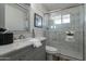 Bathroom featuring a sink with marble countertop, a toilet, and a shower with glass door and marble tiles at 11214 N 105Th Ave, Sun City, AZ 85351