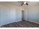 Bedroom featuring a closet, an open door, a ceiling fan, and wood-look flooring at 11214 N 105Th Ave, Sun City, AZ 85351