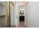 Hallway view into bathroom featuring stylish vanity with elegant mirror and ample closet space at 1126 W Elliot Rd # 1024, Chandler, AZ 85224