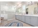 Beautiful bathroom features double sinks, stylish cabinets and large shower with white tile and glass door at 11807 W Parkway Ln, Avondale, AZ 85323