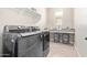 Modern laundry room featuring side by side washer and dryer units, convenient counter space, and storage at 11807 W Parkway Ln, Avondale, AZ 85323