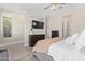 Serene main bedroom with a tufted headboard, ceiling fan, and a dresser with a wall-mounted TV at 11807 W Parkway Ln, Avondale, AZ 85323