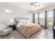 Serene main bedroom with a tufted headboard, ceiling fan, and large windows at 11807 W Parkway Ln, Avondale, AZ 85323